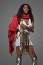 Afro-American model in Greek-style tunic with red cape and ornate belt