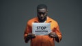 Afro-american prisoner holding Stop persecution sign, racial discrimination