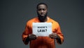 Afro-american prisoner holding where is law sign in cell, wrongly accused person Royalty Free Stock Photo