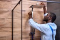 Black Professional handyman working in shower bath indoors, side view portrait Royalty Free Stock Photo