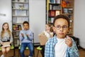 Schoolboy standing in middle of classroom and answering question in front of classmates and teacher Royalty Free Stock Photo