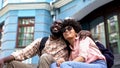Afro-american student couple hugging, sitting on university building stairs