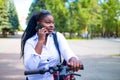 Afro american woman activate and prepay a rental e-scooter or an e-bicycle on the street Royalty Free Stock Photo