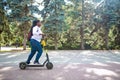 Afro american woman activate and prepay a rental e-scooter or an e-bicycle on the street Royalty Free Stock Photo