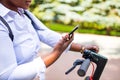 afro american woman activate and prepay a rental e-scooter or an e-bicycle on the street Royalty Free Stock Photo