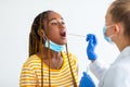 Afro american woman getting oral coronavirus swab test at hospital