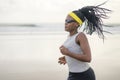 Afro American woman running on the beach - young attractive and athletic black girl training outdoors doing jogging workout at the Royalty Free Stock Photo