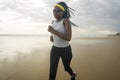 Afro American woman running on the beach - young attractive and athletic black girl training outdoors doing jogging workout at the Royalty Free Stock Photo