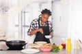 Afro american woman sprinkling salt on whisked eggs: Cooking concept