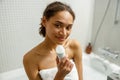 Young woman in white towel holding underarm deodorant stick for daily hygiene everyday freshness