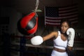 Afro american woman training boxing in gym with the United States flag in the background Royalty Free Stock Photo