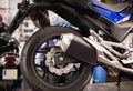 Afro american worker inspects the wheel of a motorcycle