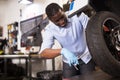 Afro american worker inspects the wheel of a motorcycle