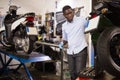 Afro american worker inspects the wheel of a motorcycle