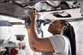 Afro Female auto mechanic work in garage, car service technician woman in overalls