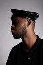 Afro Black young man wears black beret, posing over white background. Vertical. Royalty Free Stock Photo