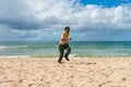 Afro Brazilian boy wearing a scout uniform running at Itapua beach in Salvador, Bahia