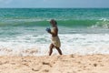 Afro Brazilian woman walking by the ocean at Itapua beach in Salvador, Bahia