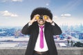 Afro businessman with binocular at the industrial port