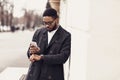 Afro businessman checking time on watches and using phone Royalty Free Stock Photo