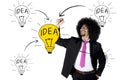 Afro businessman drawing bright light bulb Royalty Free Stock Photo