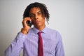 Afro businessman with dreadlocks talking using smartphone over isolated white background with a confident expression on smart face Royalty Free Stock Photo