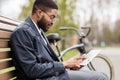 Afro businessman having break and using tablet in park Royalty Free Stock Photo