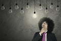 Afro businessman looking at light bulb Royalty Free Stock Photo