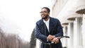 Afro businessman riding on bike to work and listening music