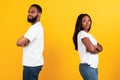 Afro couple standing back to back, yellow studio wall Royalty Free Stock Photo