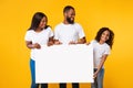Afro family holding blank white advertising billboard at studio Royalty Free Stock Photo