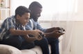 Afro father and son playing video games with joysticks Royalty Free Stock Photo