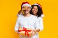 Afro girl covering eyes of her boyfriend and giving Christmas present Royalty Free Stock Photo
