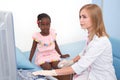 Afro girl sitting on bed, while ultrasound of knee join.