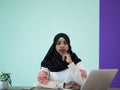 afro girl wearing a hijab is disappointed and sad sitting in her home office and using a laptop Royalty Free Stock Photo