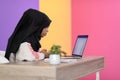 afro girl wearing a hijab is disappointed and sad sitting in her home office and using a laptop Royalty Free Stock Photo