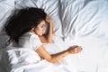 Afro-haired upset woman alone in bed with empty space next to her. Divorse, loss of loved one concept, top view. Royalty Free Stock Photo