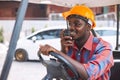 Afro loader worker is talking on the walkie-talkie in forklift