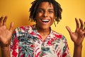 Afro man with dreadlocks on vacation wearing floral shirt over isolated yellow background very happy and excited, winner Royalty Free Stock Photo