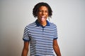 Afro man with dreadlocks wearing striped blue polo standing over isolated white background sticking tongue out happy with funny Royalty Free Stock Photo
