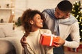 Afro man giving Christmas present to wife, celebrating holidays Royalty Free Stock Photo