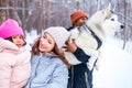 afro man with his caucasian wife having fun with a beautiful daughter playing husky in snowy park Royalty Free Stock Photo