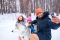 afro man with his caucasian wife having fun with a beautiful daughter playing husky in snowy park Royalty Free Stock Photo