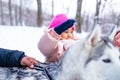 afro man with his caucasian wife having fun with a beautiful daughter playing husky in snowy park Royalty Free Stock Photo