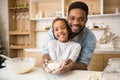 Afro man holding daughter hands with heart shaped pastry inside Royalty Free Stock Photo