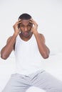 Afro man suffering from headache in bed Royalty Free Stock Photo