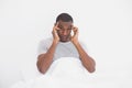 Afro man suffering from headache in bed Royalty Free Stock Photo