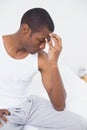 Afro man suffering from headache in bed Royalty Free Stock Photo