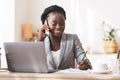 Afro Secretary Taking Notes And Talking On Cellphone In Office