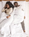 Afro woman annoyed by her boyfriend sprawled out all over bed Royalty Free Stock Photo